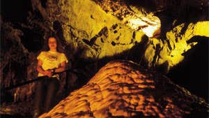 Person standing inside the cave at Crag Cave