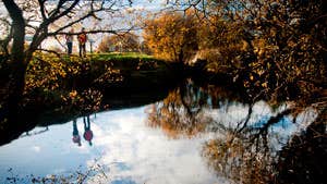 Two walkers on the banks of the Shannon Pot in autumn