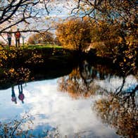 Two walkers on the banks of the Shannon Pot in autumn