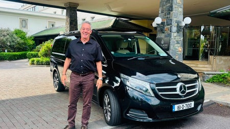 Aiden from Executive Explorer Luxury Tours standing beside a Mercedes luxury car