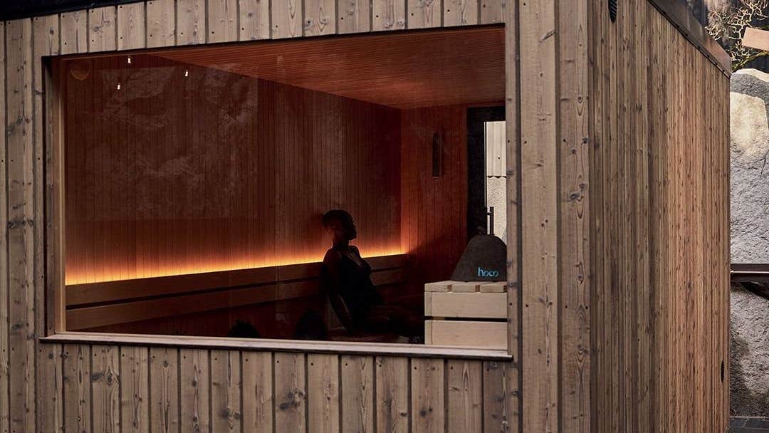 A wooden cabin with a large window and a sauna inside