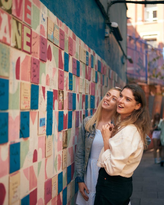 Two women looking at the wall art on Love Lane in Temple Bar