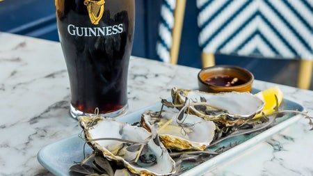 A pint of Guinness with three oysters
