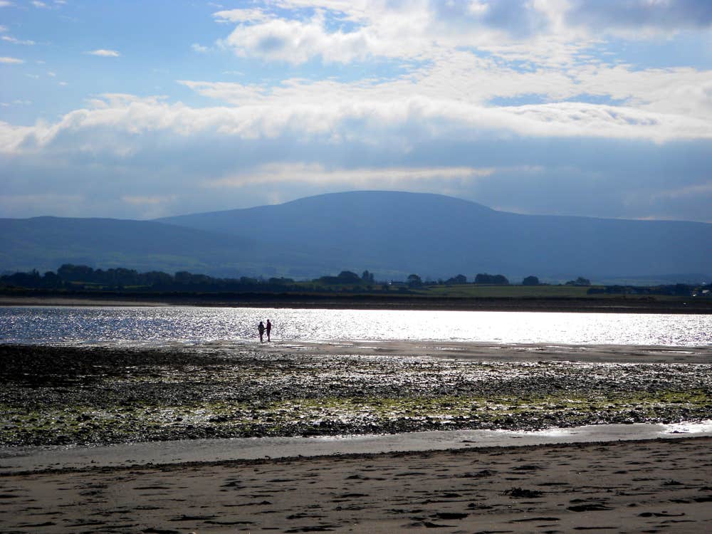 People walking on Strandhill Beach, Sligo on a sunny day.