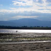 People walking on Strandhill Beach, Sligo on a sunny day.