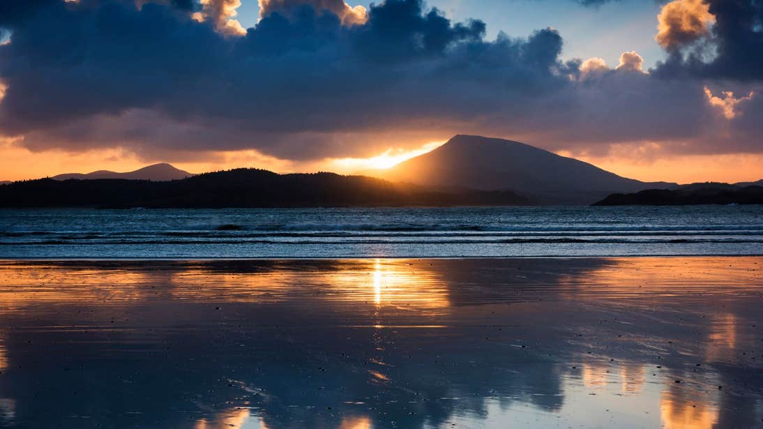 A stunning sunset behind mountains at Downings Beach.