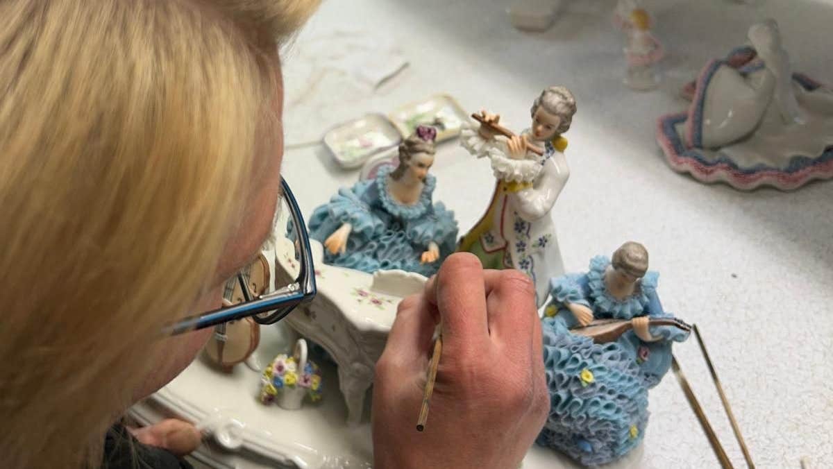 A lady painting a porcelain figurine