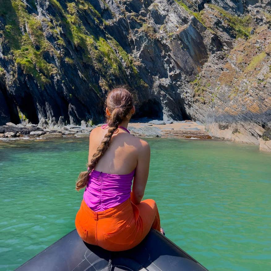 Woman sitting on the edge of boat on the Cork Ocean Escapes.