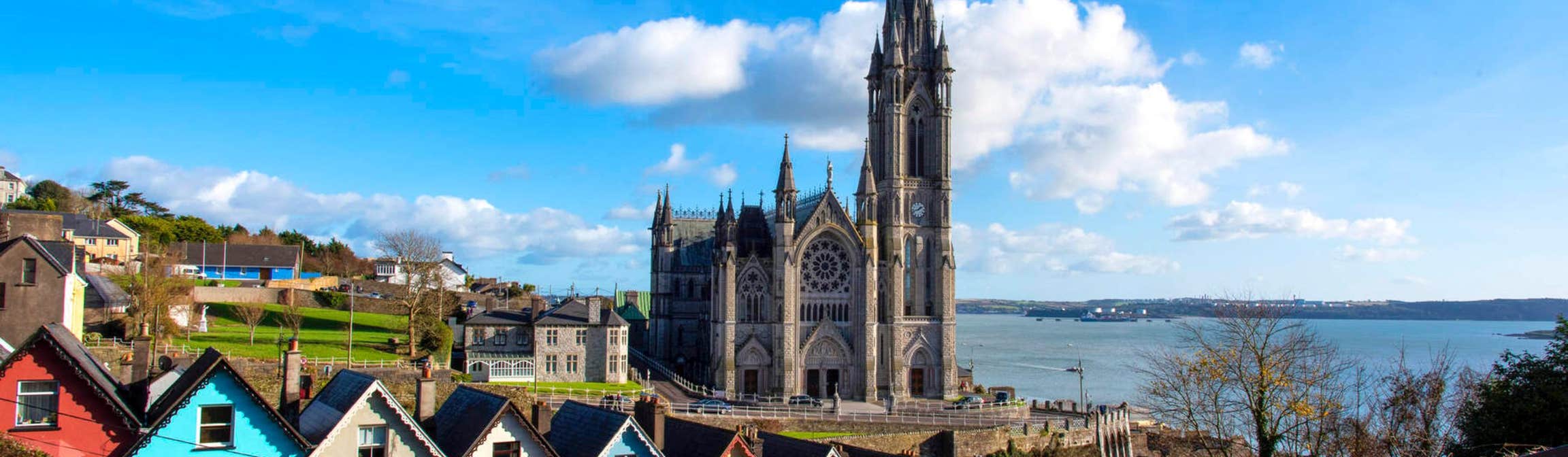 Colourful buildings in front of a church by the sea in Cobh, County Cork
