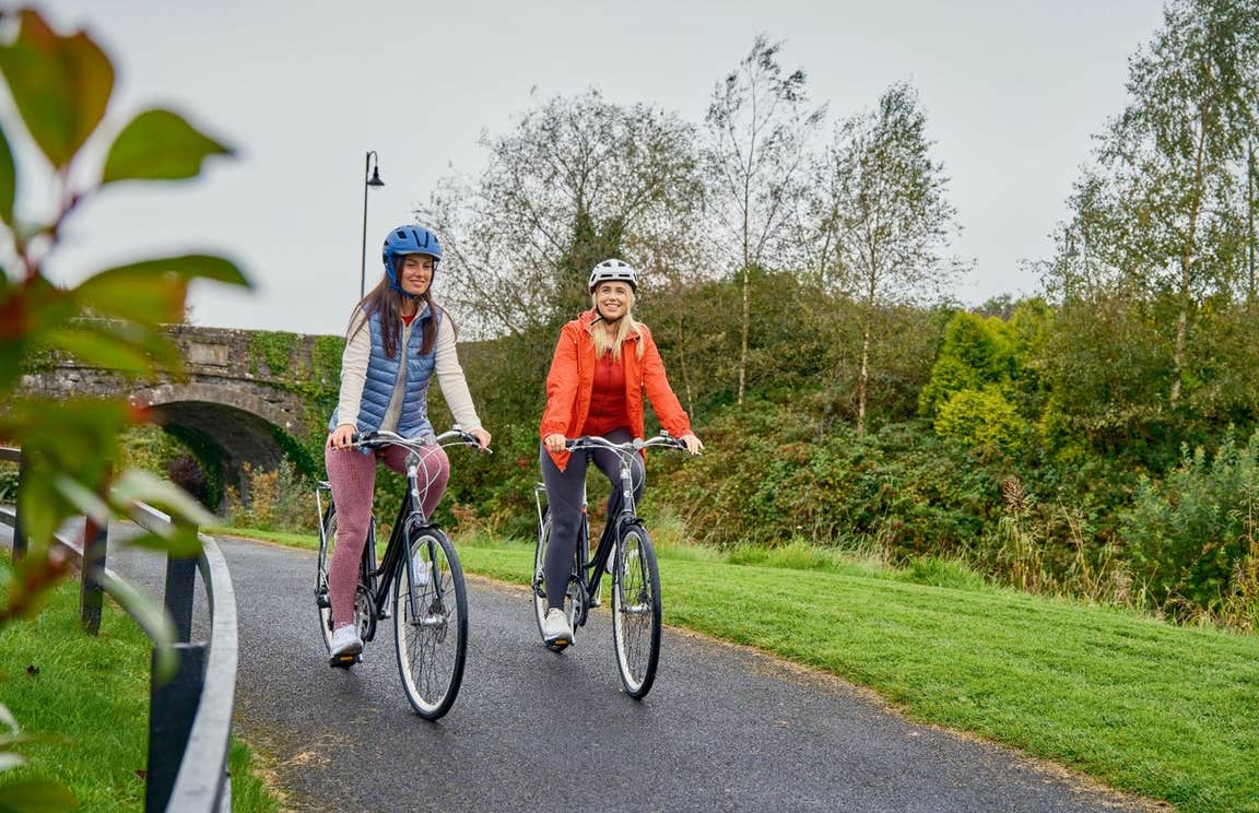 Two people cycling on a greenway