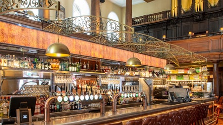 Long old fashioned bar with lots of ornate wood décor