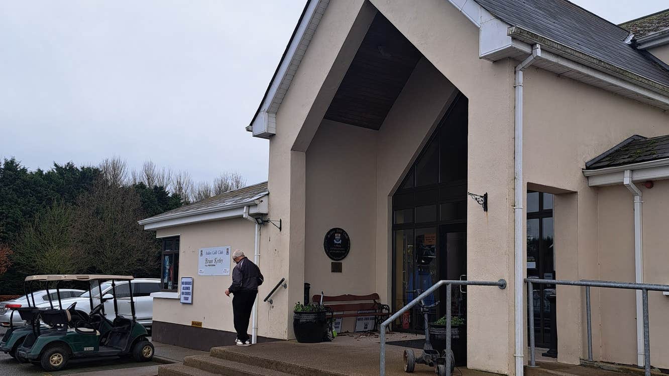 Entrance to a building with steps leading up to it and some golf buggies to the left