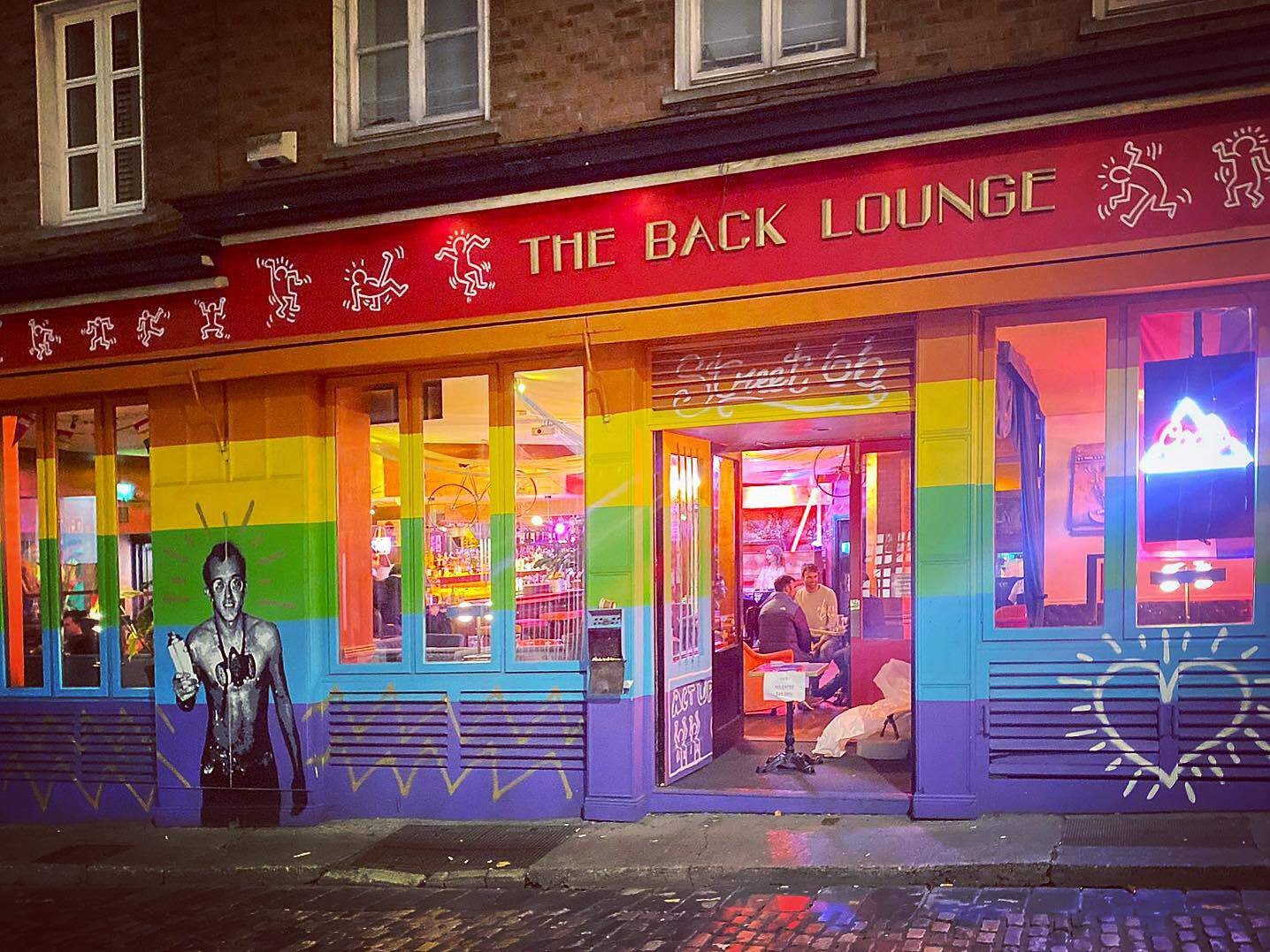 The exterior facade of The Back Lounge painted in the Pride flag colours.