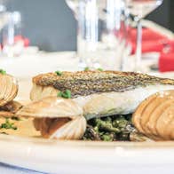 A fillet of fish on a plate with clams