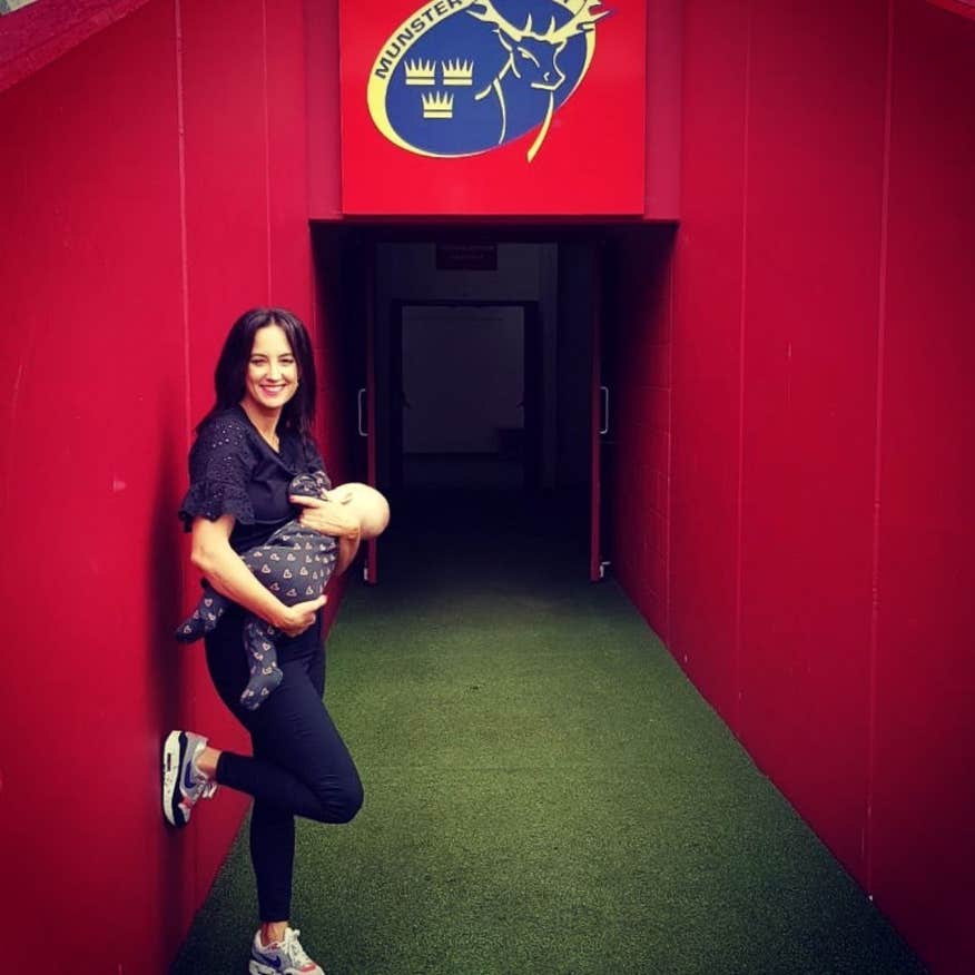 Woman holding a baby in Thomond Stadium Park.