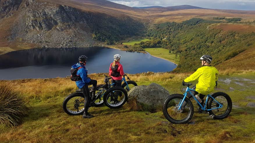 Three people on bikes looking at gorgeous views of the Wicklow Mountains