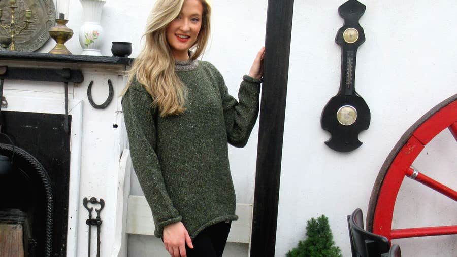 A lady standing and posing for the camera wearing a sweater from Tweed