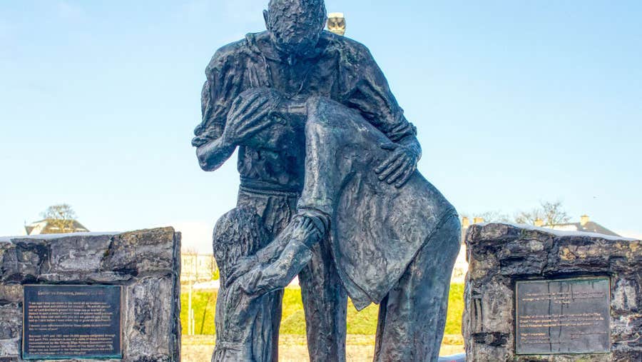 A statue of parents embracing a child in despair