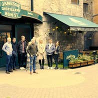 A guide takes a picture of a group of people outside the Jameson Bow Street Distillery in Dublin