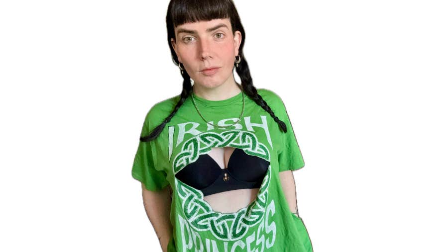 A woman wearing a green Irish theme T-shirt with front missing to show black bra underneath