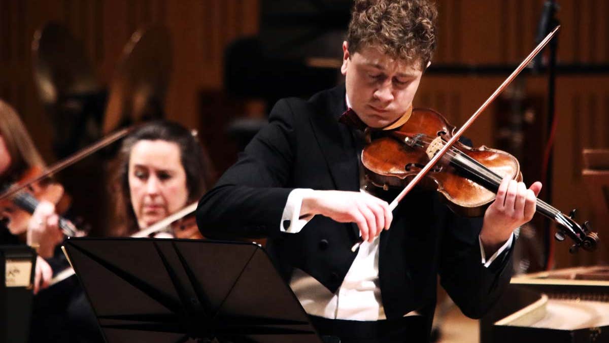 Patrick Rafter playing the violin in concert attire.