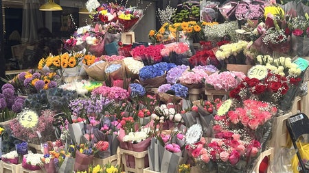 A vibrant Dublin street flower stall bursts with roses, tulips, hydrangeas and sunflowers, wrapped and ready for eager buyers—a fitting symbol of romance in a city with an unexpected connection to the patron saint of love.