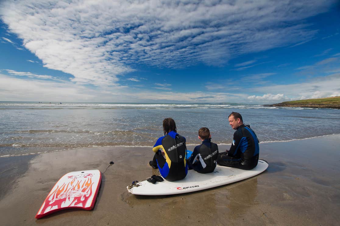 Family at the beach in West Cork with surfboards