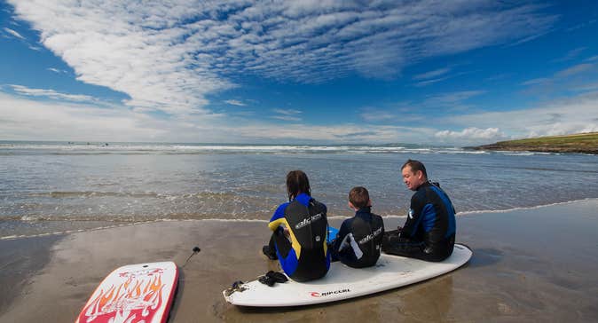 Family at the beach in West Cork with surfboards