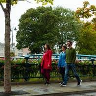 Three people walking on a footpath in Sligo Town.