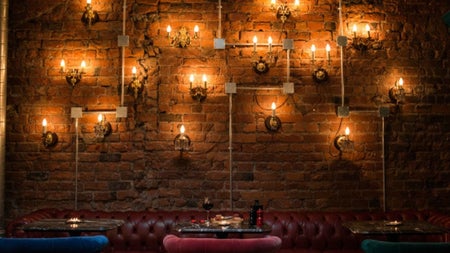 Exposed brick wall with vintage leather seating and warm wall lighting