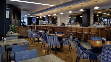 A modern bar with tables and chairs and lounge seating