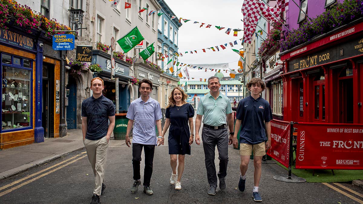 A family strolling along a colourful city street