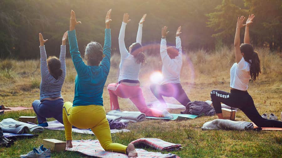 Five ladies in an outdoor setting taking part in a Pilates class