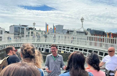 A guide with a group by the Ha Penny Bridge Dublin city