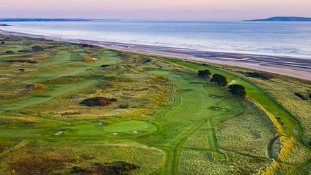 A view of a golf course with the sea in the background