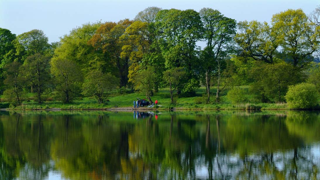 Image of Lough Muckno, Monaghan, surrounded by trees with people in the distance