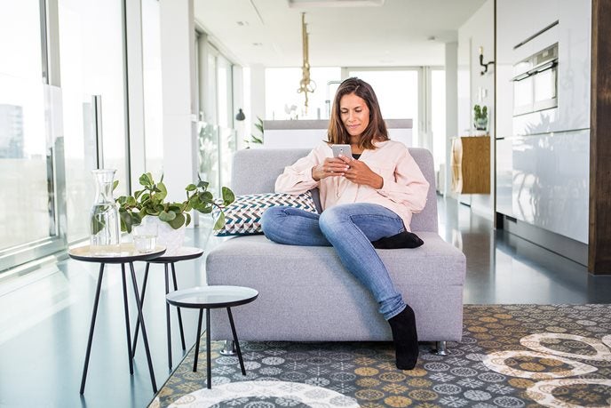 Vrouw op de bank met smartphone