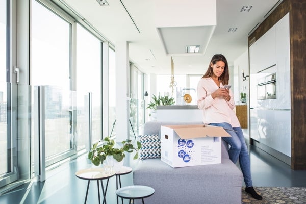 Vrouw met verhuisdoos geeft verhuizing door