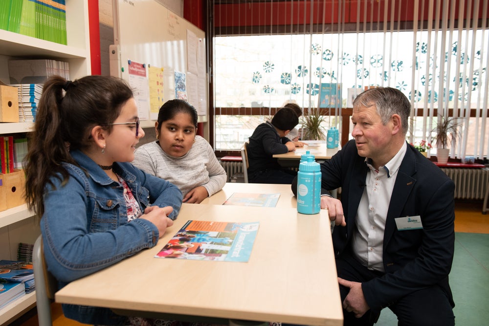 Evides medewerker in gesprek met leerlingen op school