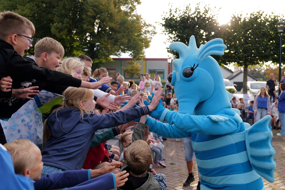 Mascotte Evi groet de kinderen.