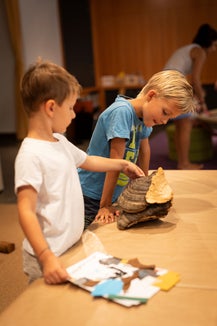 Le famiglie che, durante una visita al museo con i bambini, hanno voglia di fare una pausa, nei mesi di luglio e agosto sono le benvenute nello “Spazio famiglia”. (Foto: Museo Archeologico dell’Alto Adige/ Marion Lafogler)