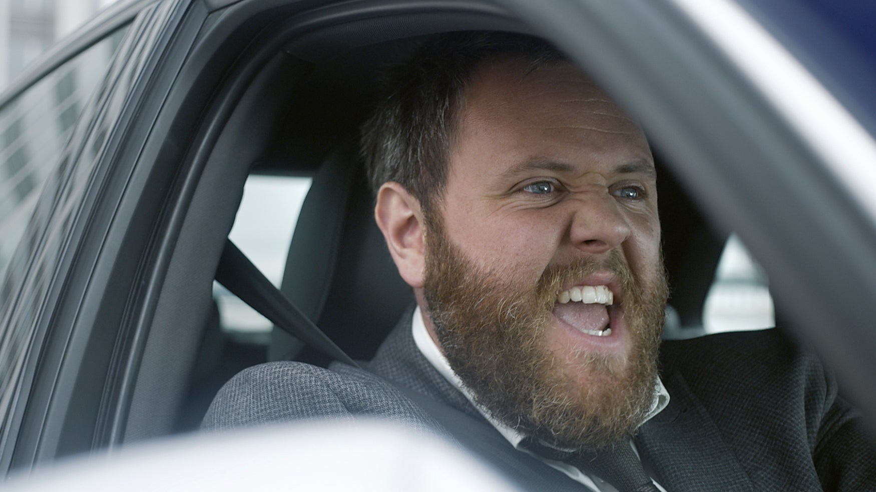 A guy singing in a car.