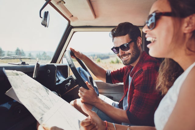 Happy couple in the car on a road trip.