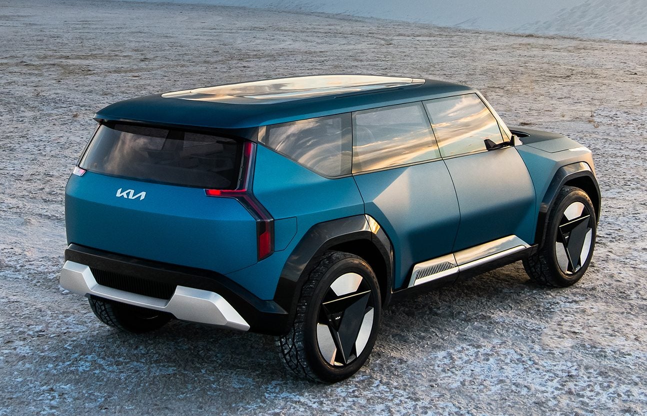 Rear-three quarter picture of a blue Kia EV9 parked on the desert