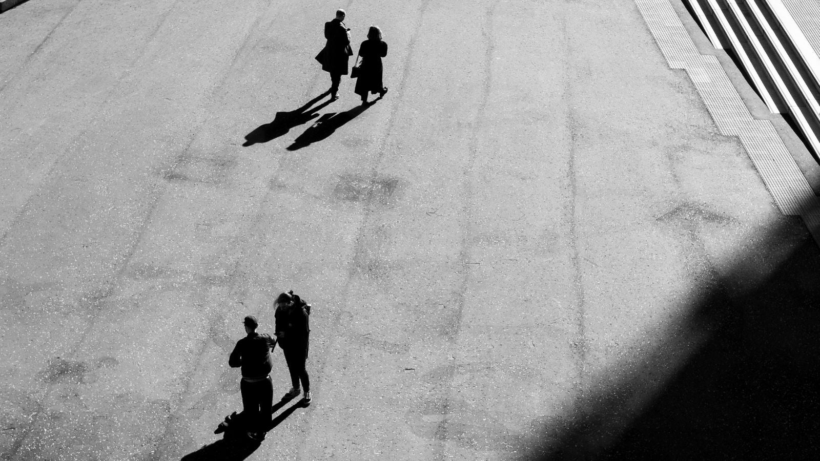 Black and white photo of people walking across an open courtyard