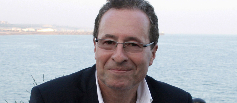 Close up photograph of Peter James in front of the ocean