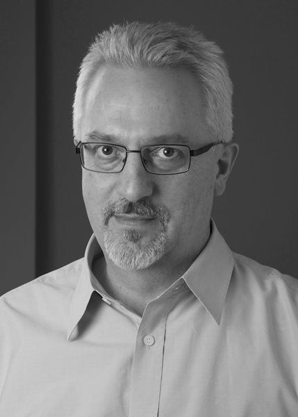 A black and white photograph of author Alan Hollinghurst.