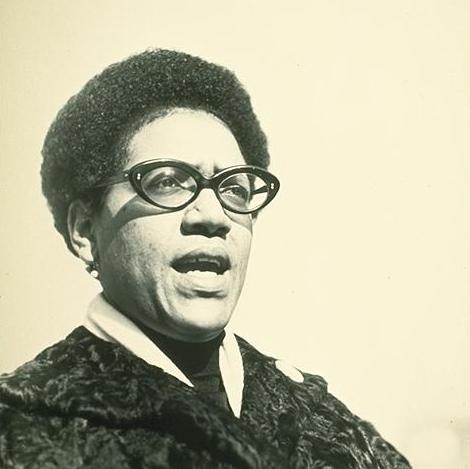 Black and white photograph of Audre Lorde mid-speech