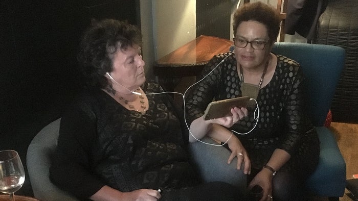 Carol Ann Duffy and Jackie Kay sharing headphones to watch the match backstage