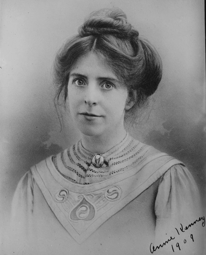 A black and white photograph of Annie Kenney smiling, taken in 1909